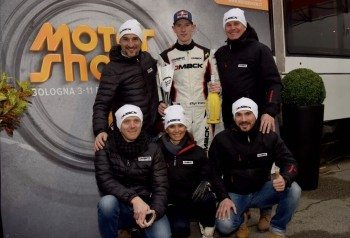 Elfyn Evans flanked by representatives of Dmack and Italy dealer OMPI Racing Tyres